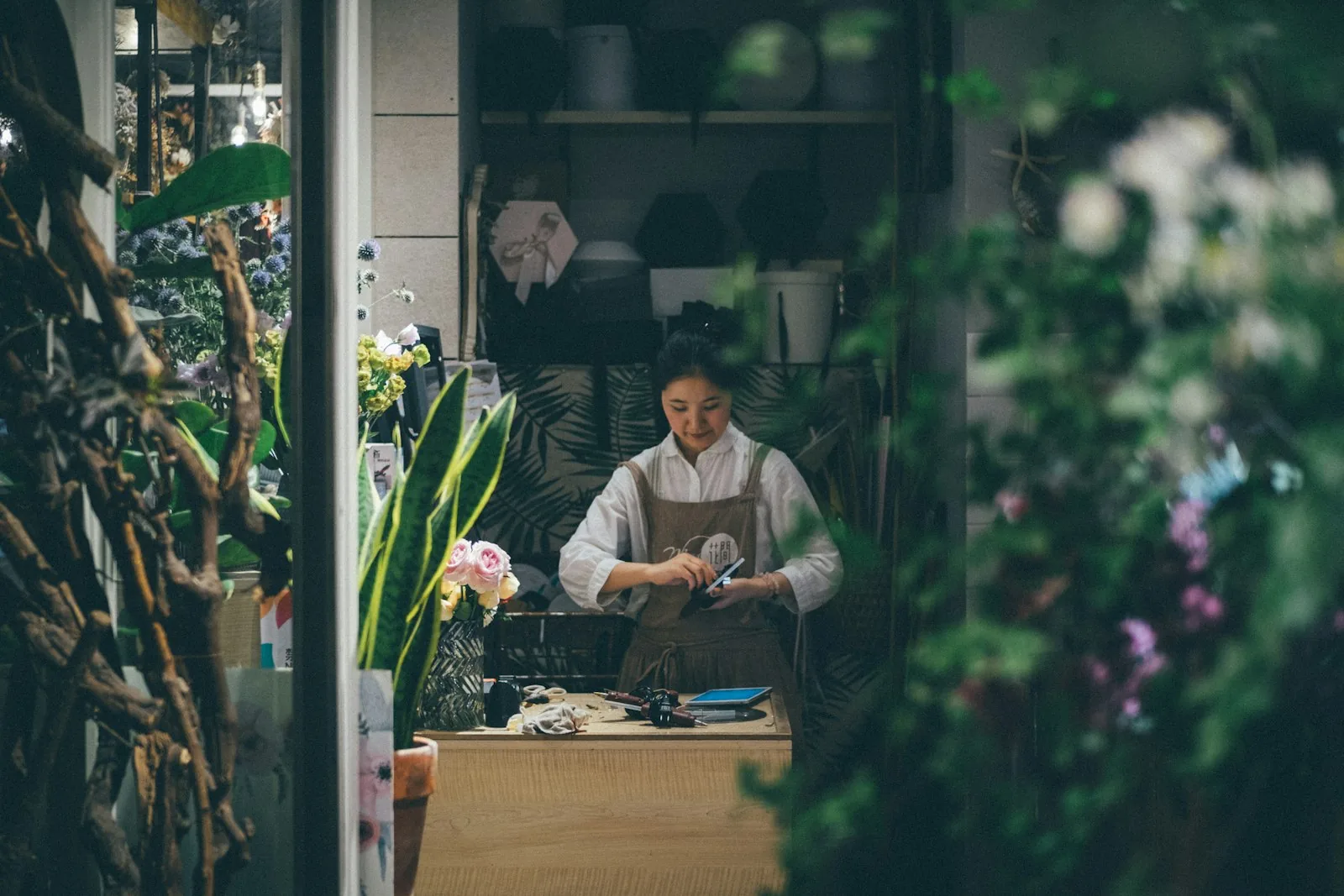A small business owner working at an arranging table